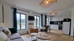 Un appartement moderne comprenant un espace de vie, un coin repas et une cuisine.