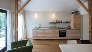 Een moderne keuken met houten kastjes, een ingebouwde oven en een raam met gordijnen.