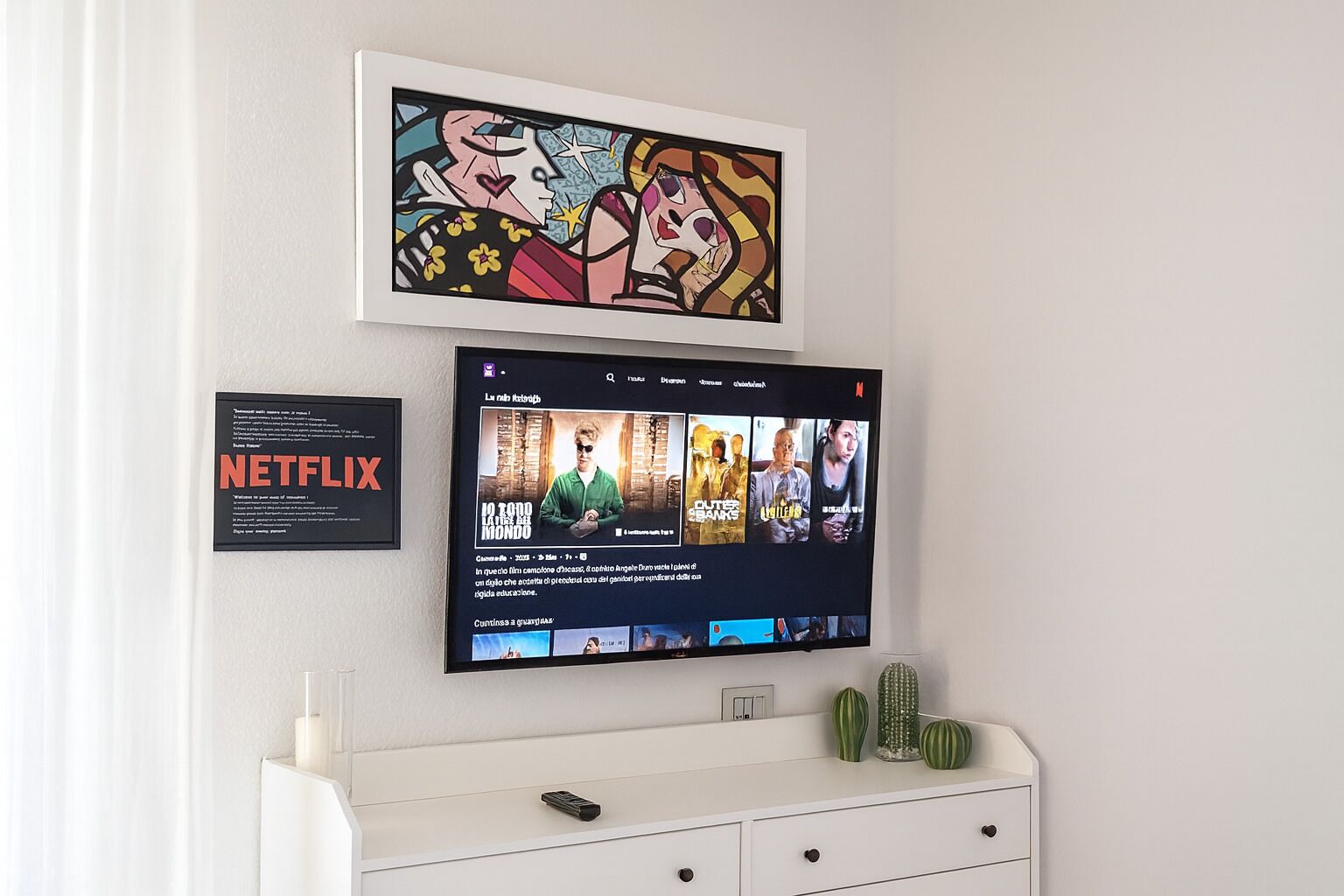 Ein an der Wand befestigter Fernseher zeigt eine Netflix-Oberfläche mit Filmangeboten.