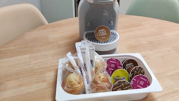 Una cocina con una cafetera y una bandeja de cápsulas de café.
