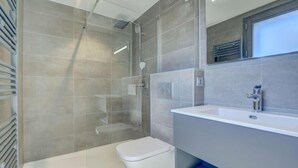 A modern bathroom with a glass-enclosed shower, a white toilet, and a large sink with a mirror above it. - 140m from ski lifts, 2nd floor, view mountain/resort, terrace, fireplace or stove, tv, 114m² (Morzine)