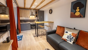 Una cocina moderna con una isla central, taburetes de bar y un comedor.