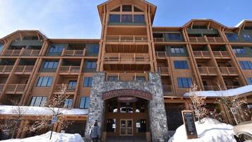 A multi-story hotel with a stone facade and wooden balconies.