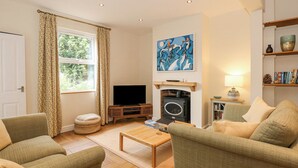 A cozy living room with a fireplace, a television, and comfortable seating.