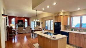 Una cocina amplia con armarios de madera, una isla central y un comedor con sillas y una mesa.