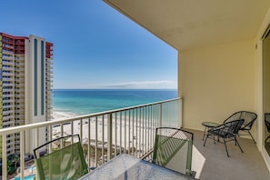 Un balcone con vista sulla spiaggia e un palazzo alto.
