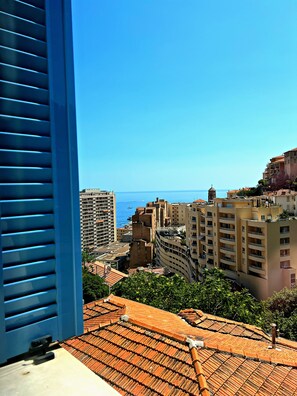 Un paisaje urbano costero con edificios, cielo despejado y el mar al fondo.