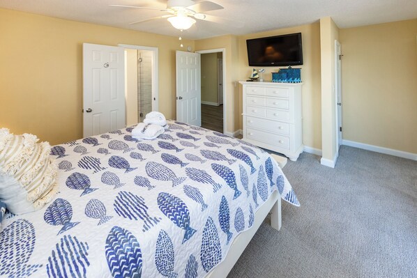 A bedroom with a bed, a dresser, a ceiling fan, and a TV on the wall. - Tern About! Stunning & Spacious Pool, Ocean Views, and Easy Bach Access! (Virginia Beach)