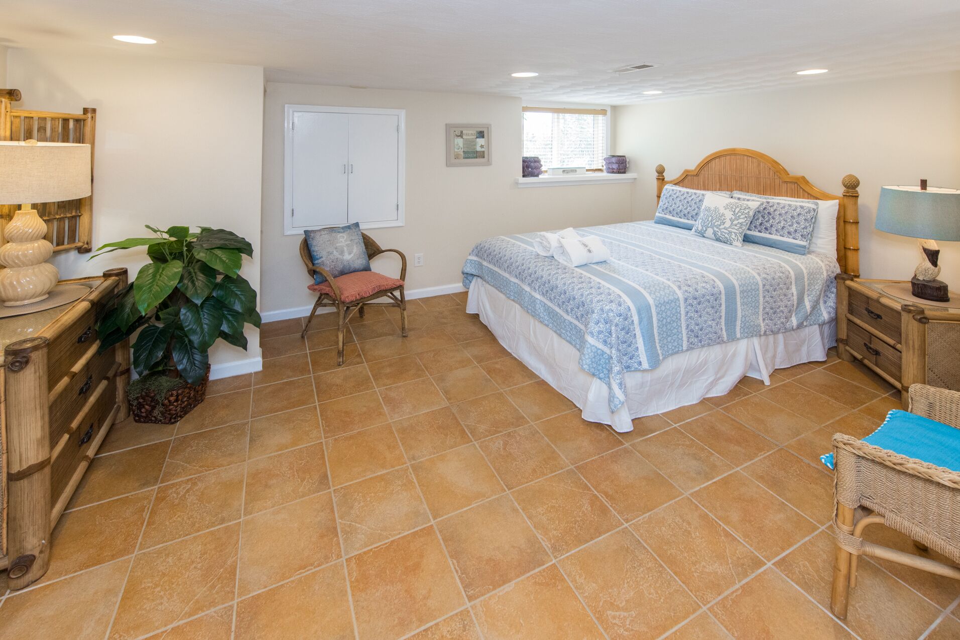 A bedroom with a bed, a chair, a desk, and a window.