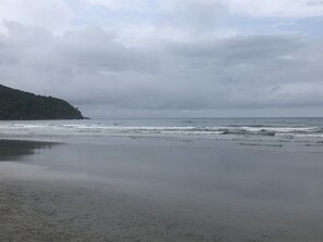 A beach with waves and a cloudy sky.