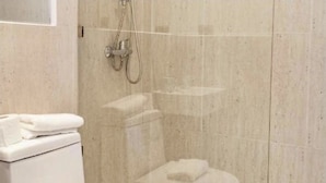 A bathroom with a toilet, a sink, and a shower area. - Escalera al puerto Guest House  (Valparaiso)
