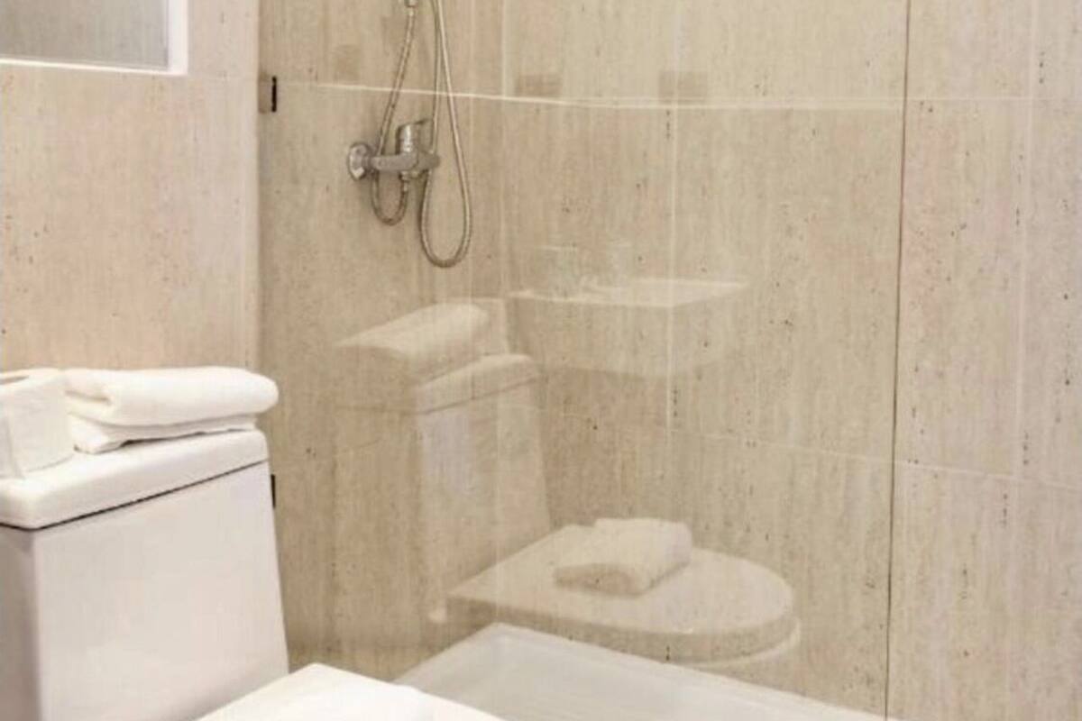 Ein Badezimmer mit Toilette, Waschbecken und Duschbereich.