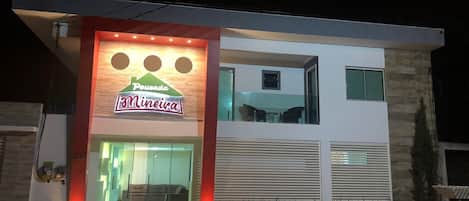 A modern building with a sign for "Pousada Mineira" at the entrance.