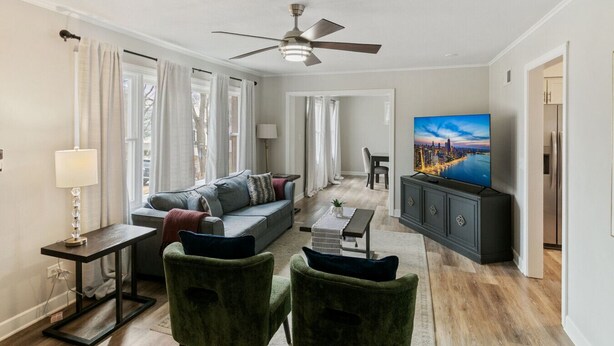 A modern living room with a sofa, a TV, and a ceiling fan. - Modern Home near DT Libertyville and Naval Base (Libertyville)
