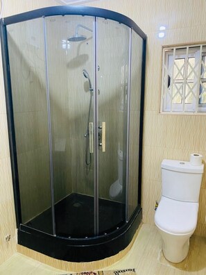 Chuveiro, toalhas de banho, sabonete, papel higiênico