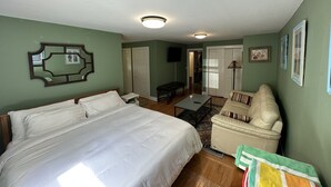 Une chambre avec un grand lit, un canapé, un bureau et une télévision.
