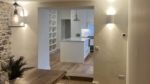 A modern kitchen with white cabinets, a wooden island, and pendant lighting. - In Town Beautiful Trim Castle Cottage   (Trim)