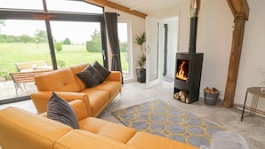 A modern living room with a yellow sofa, a rug, and a fireplace.