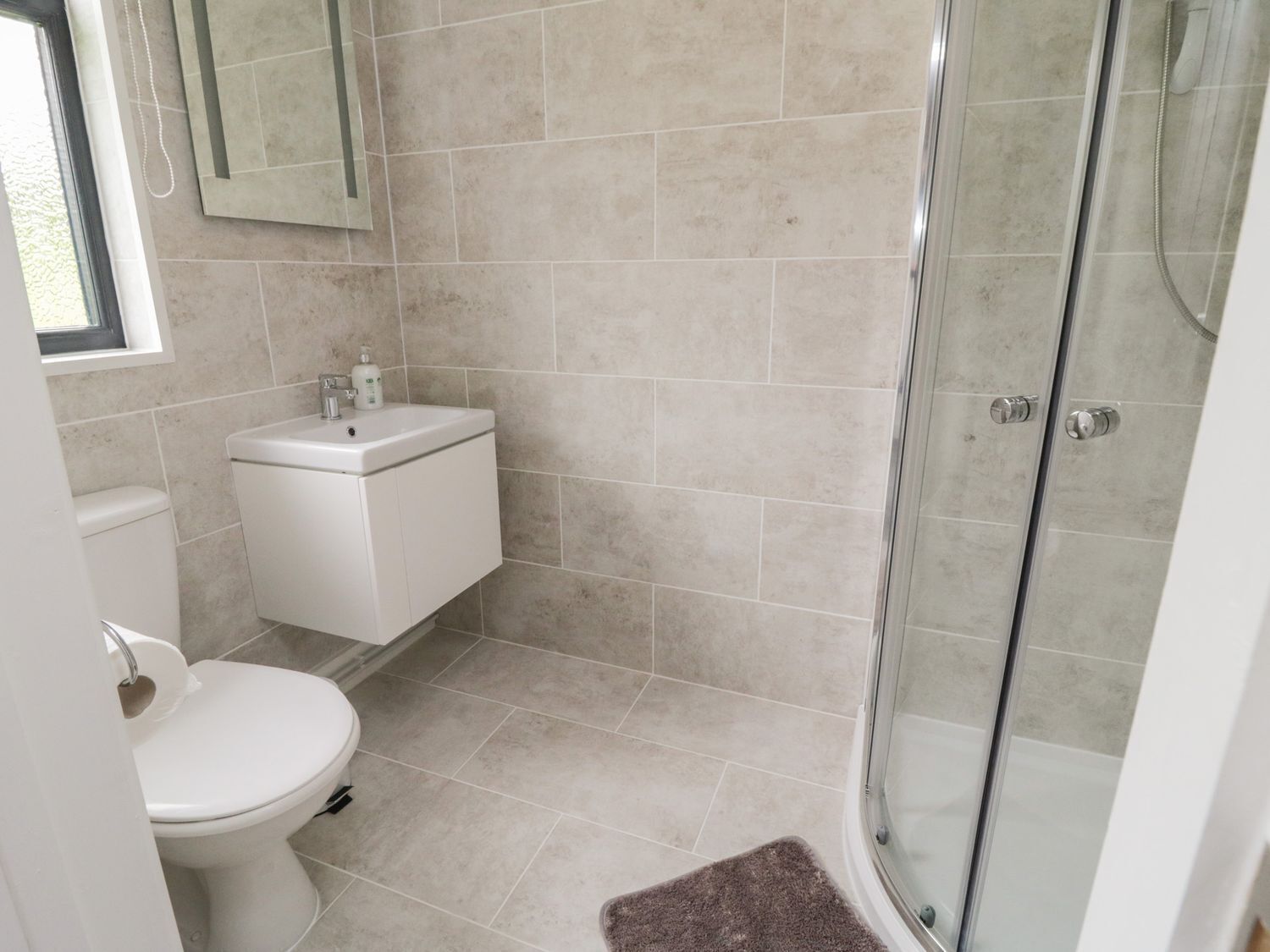 A bathroom with a toilet, sink, and shower.