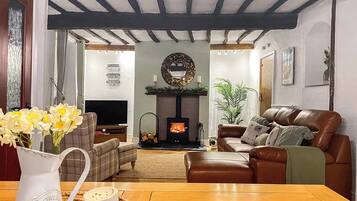 A cozy living room with a fireplace, leather sofa, and a TV.