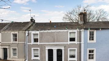 A row of terraced houses with a central entrance, each with a distinct color and a small window.