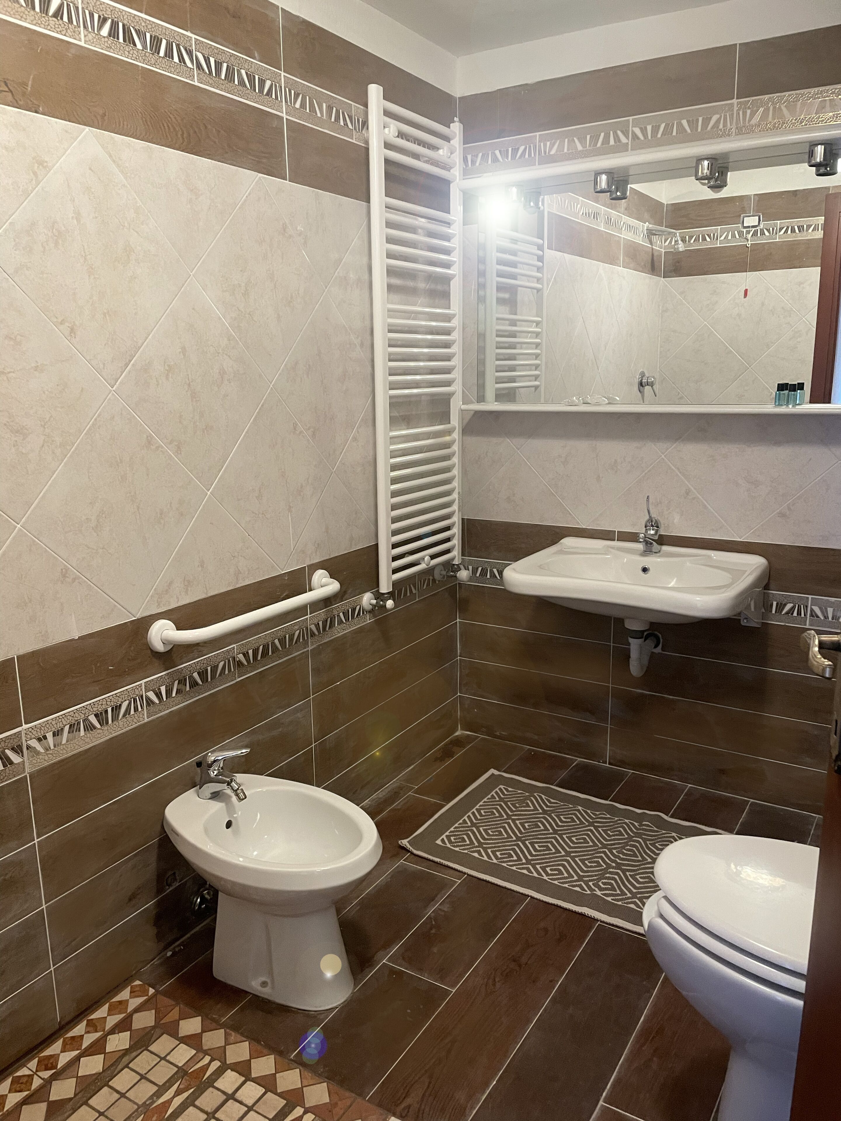 Un bagno con bidet, lavandino e WC.