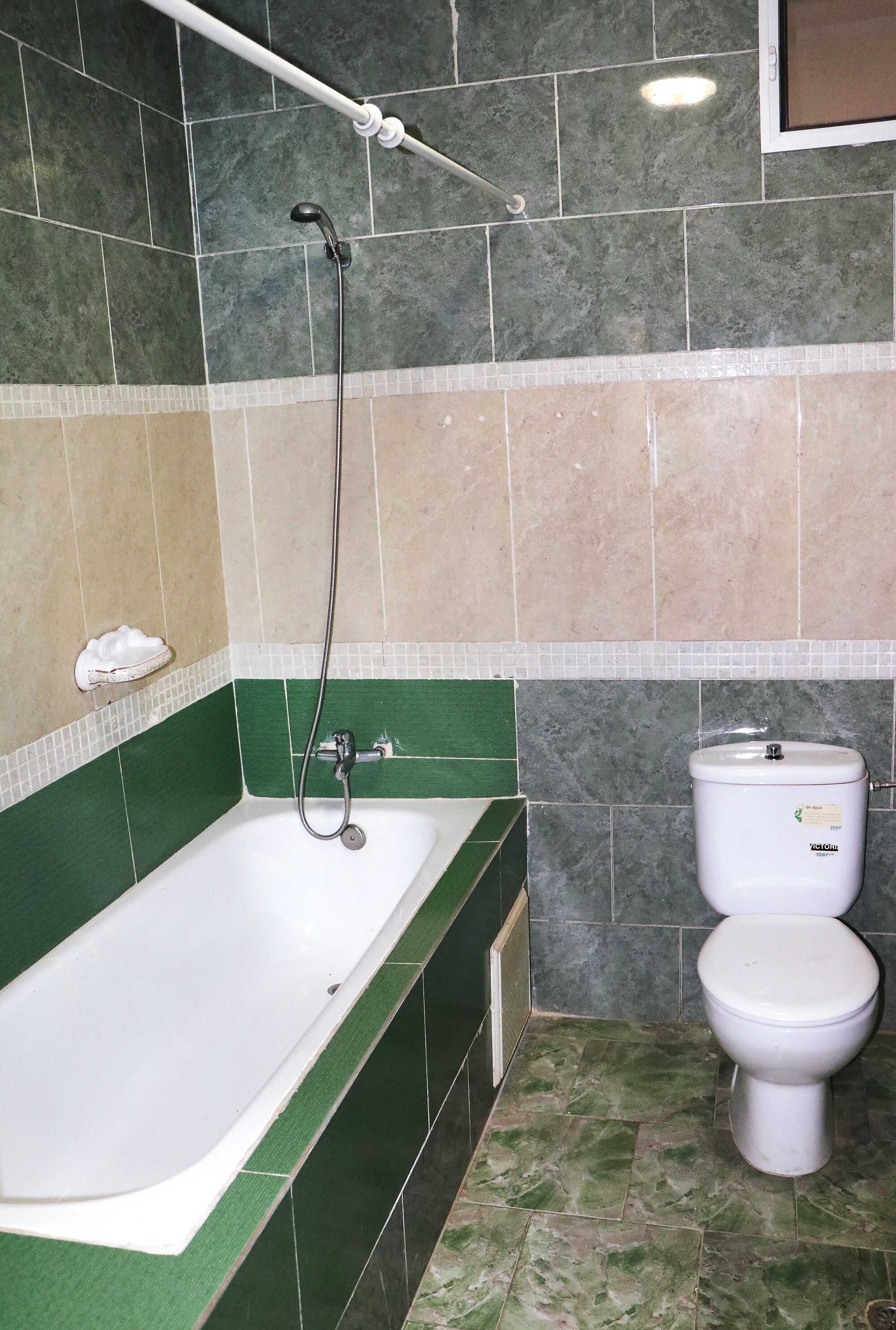 Ein Badezimmer mit Badewanne, Toilette und Dusche.
