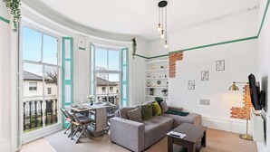 Ein modernes Wohnzimmer mit Sofa, Couchtisch und Essbereich.