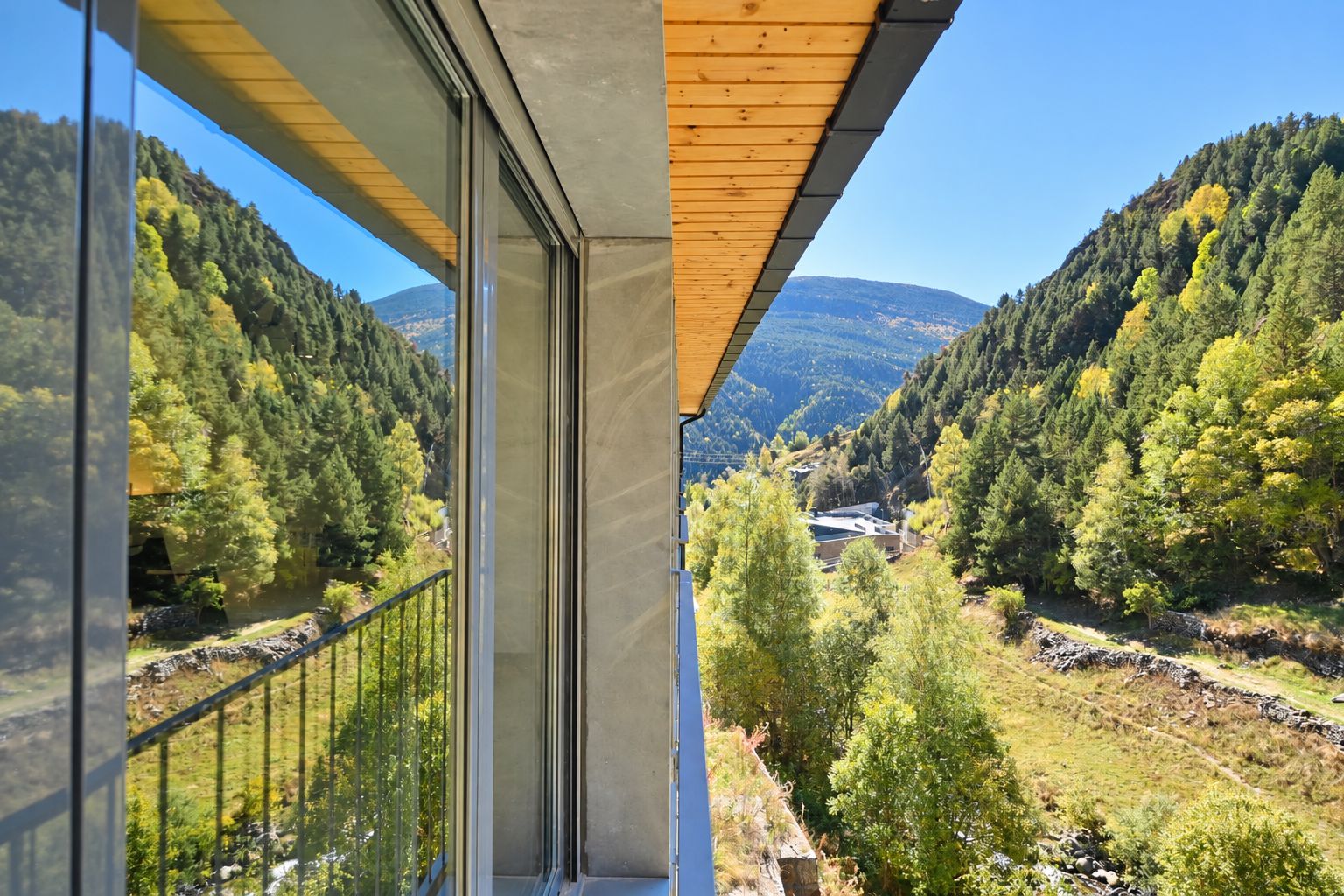 A balcony with a view of a valley and mountains.