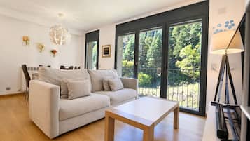 Ein modernes Wohnzimmer mit einer Couch, einem Couchtisch und einem Essbereich mit Stühlen.