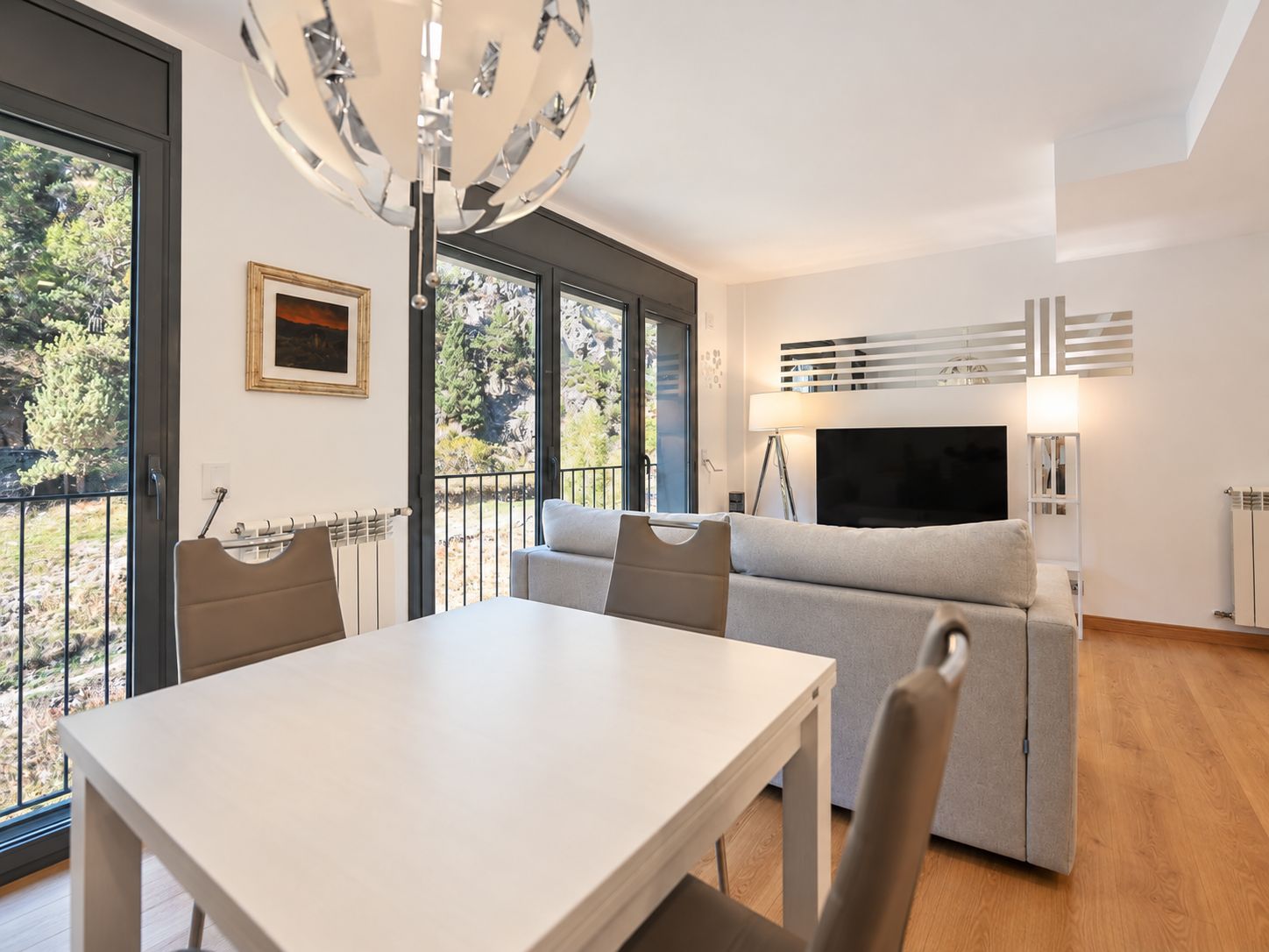 A modern living room with a sofa, a TV, and a dining table.