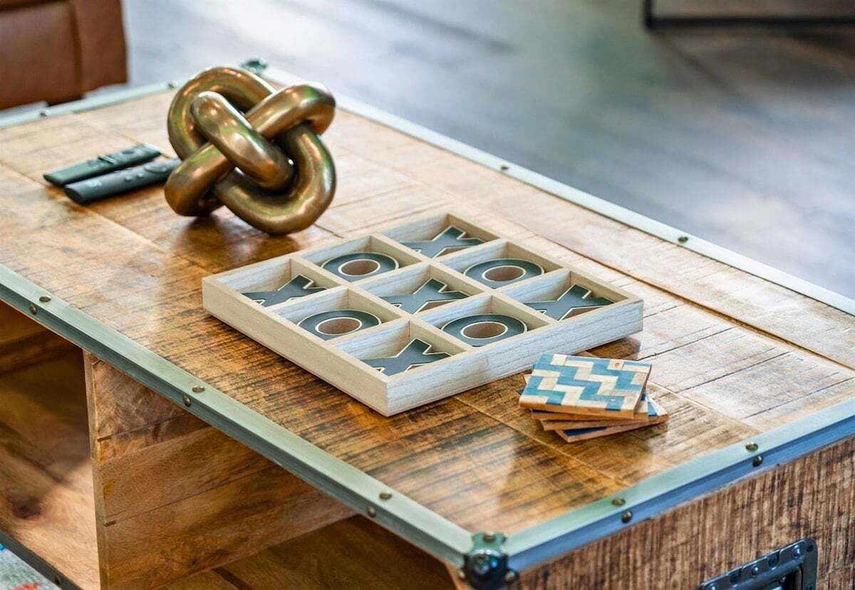 Ein Holztisch mit einem Holzpuzzle, einem Messing-Schlüssel und einer Fernbedienung.