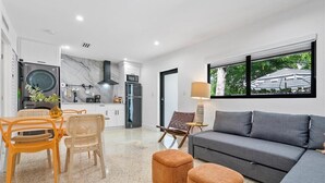 Un salon moderne avec un canapé gris, des fauteuils orange et une table à manger.