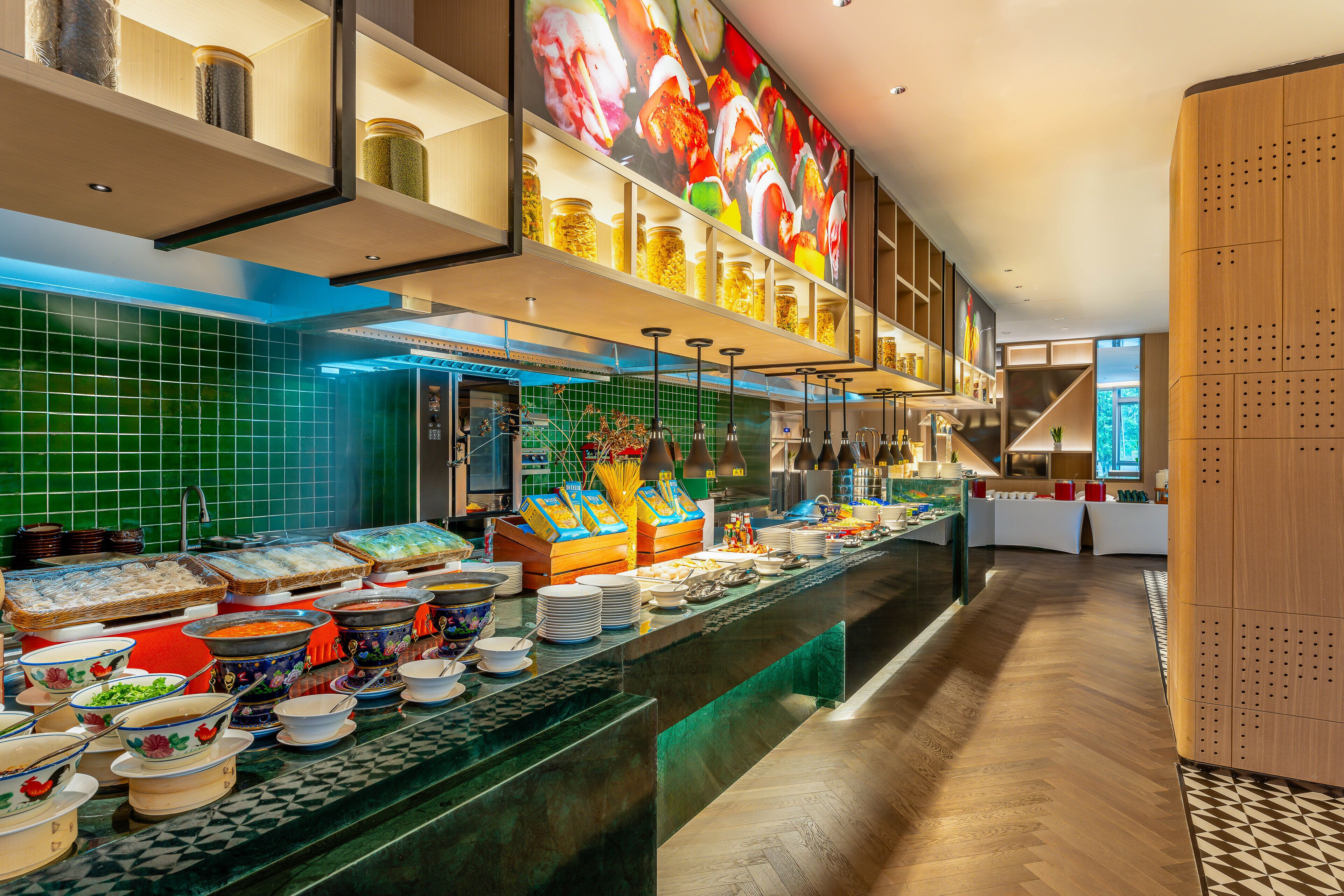 A buffet area with various food items and a large mural on the wall.