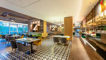 Un restaurante moderno con un suelo de diseño geométrico, techo de madera y diferentes opciones de asientos, incluyendo mesas y sillas.