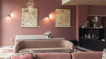 A modern living room with a sofa set, a console table with decorative items, and abstract wall art.