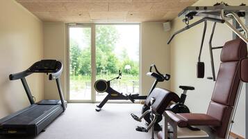 A home gym with a treadmill, stationary bike, and weight bench.