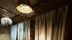 A room with wooden walls, checkered floor tiles, and curtains. - DAR SANAE SURF (Aourir)