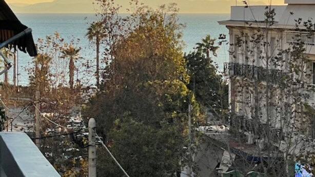 A coastal cityscape with buildings, trees, and a view of the sea. - Athens Faliro Beach Residence, by the city center (Paleo Faliro)
