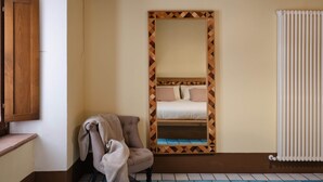 A room with a bed, a chair, a wooden cabinet, and a radiator. - Le Dimore di Borgo Tessile - Feronia (Orvieto)
