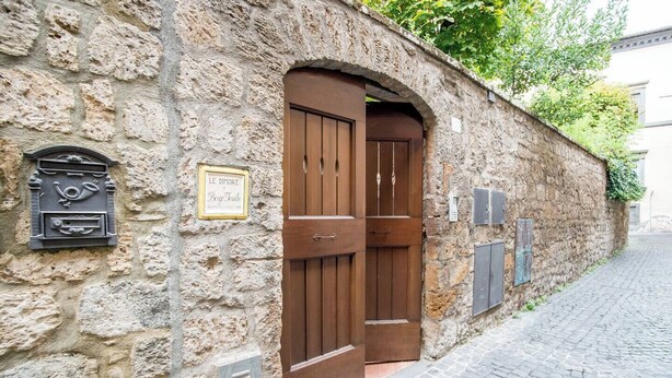A stone building with a wooden double door, a mailbox, and a sign reading "LE DIMORE." - Le Dimore di Borgo Tessile - Feronia (Orvieto)