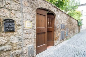 Un edificio de piedra con un par de puertas de madera, un buzón y un letrero que dice "LE DIMORE".