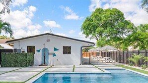 A house with a swimming pool, a fenced backyard, and a tree. - Relax and Unwind Poolside Escape (Miami)
