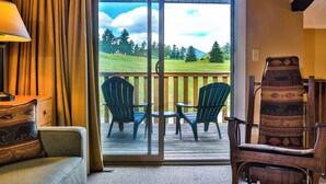 A room with a sliding glass door leading to a deck with two chairs and a table. - Colden Lodge u15 - Enjoy Mountain Views (Lake Placid)