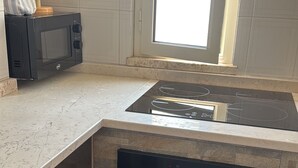 A kitchen with a built-in oven, microwave, and stove. - Apartment 'Paola' with Private Terrace and Air Conditioning (san pietro in bevagna)
