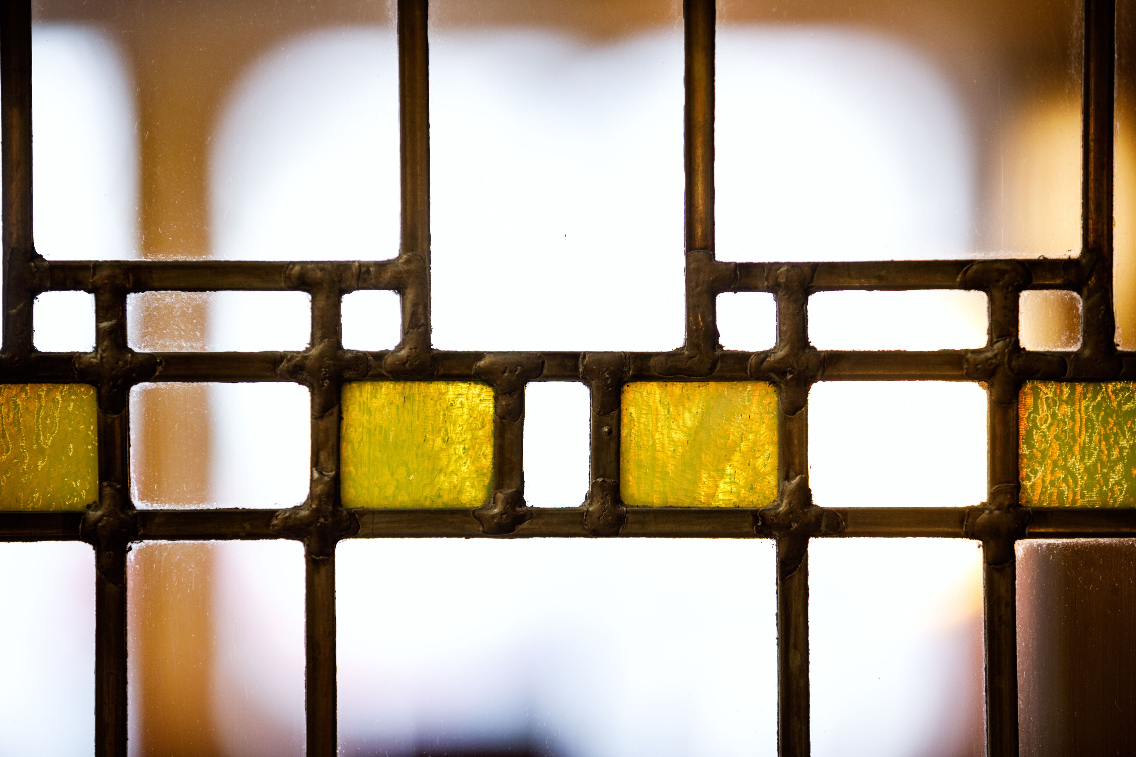A close-up of a window with a grid pattern and frosted glass panes.