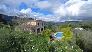 A stone villa with a pool, surrounded by lush greenery and mountains. - Holiday Home 'Pla De Ses Rotes' with Mountain View, Wi-Fi and Air Conditioning (Campanet)