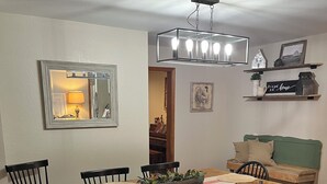 A dining area with a wooden table, black chairs, and a hanging light fixture. - Enjoy rural Missouri and a quiet getaway at White Cottage Farm. (Bogard)