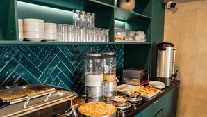 A buffet setup with various food items and serving utensils.