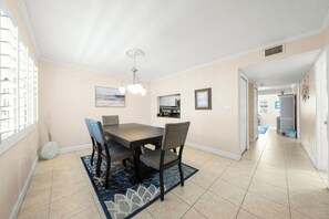 A dining area with a table, chairs, and a patterned rug. - Sea Shell by Beachside Management (Siesta Key)